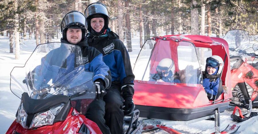 Rovaniemi: Family Snowmobile Safari with Campfire and Snacks - Parent snowmobiles in the woods near Rovaniemi